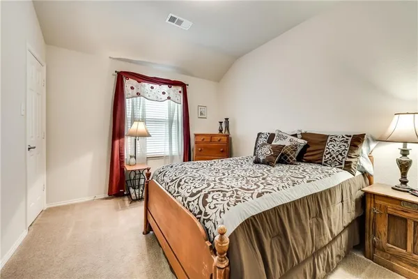 a bed sitting in a bedroom next to a window with a dresser
