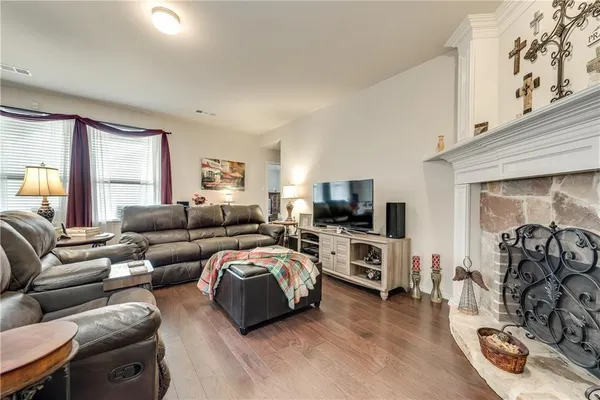 a living room with furniture a flat screen tv and a fireplace