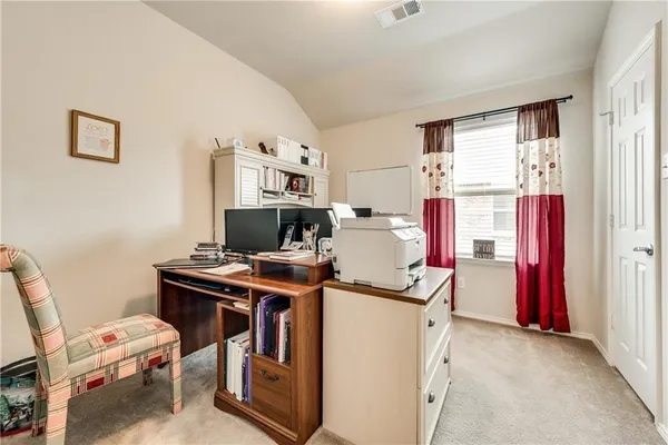 a view of a workspace with furniture and a window