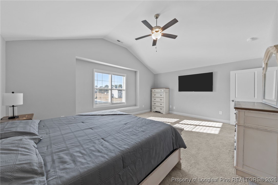 298 Turkey Trot Lane Raeford, NC 28376 - Photo 23 of 43 a bedroom with a large bed and a chandelier