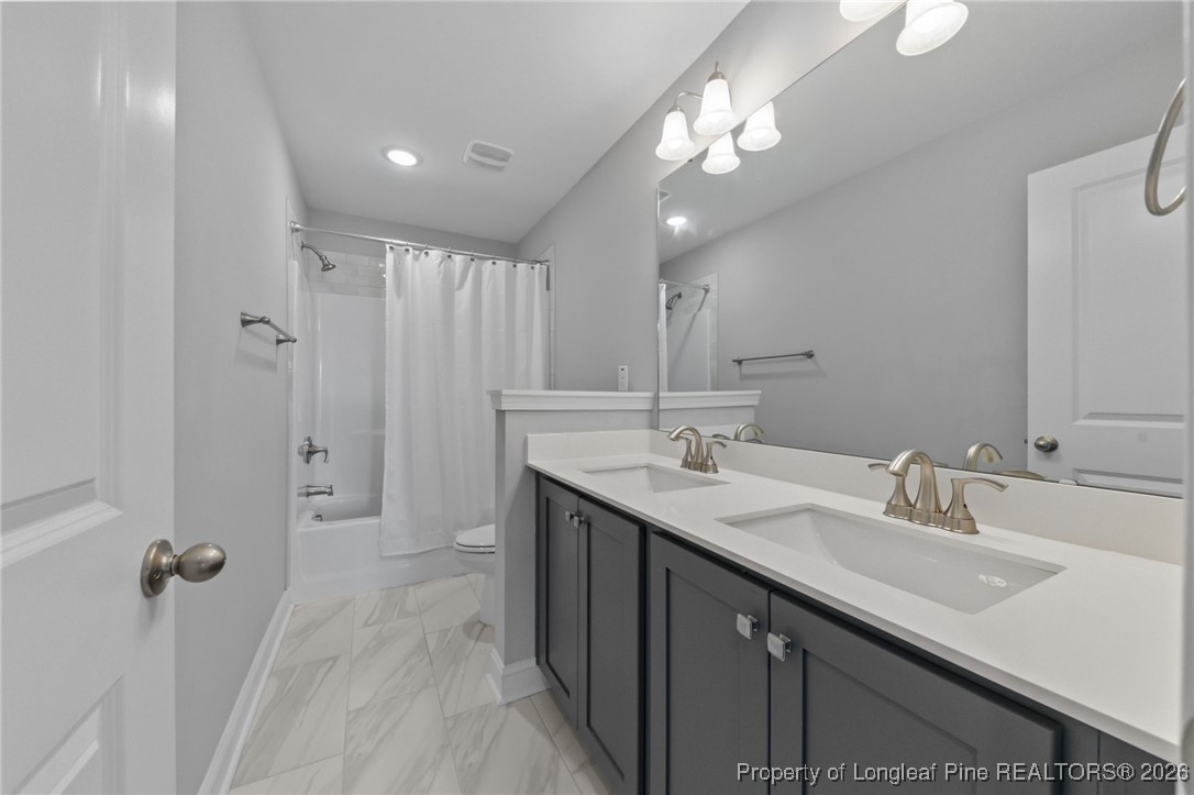 298 Turkey Trot Lane Raeford, NC 28376 - Photo 24 of 43 a bathroom with a double vanity sink and a mirror