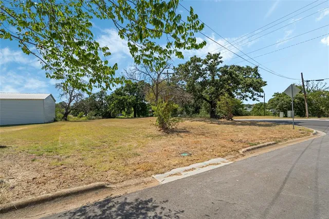 a view of a yard with large trees