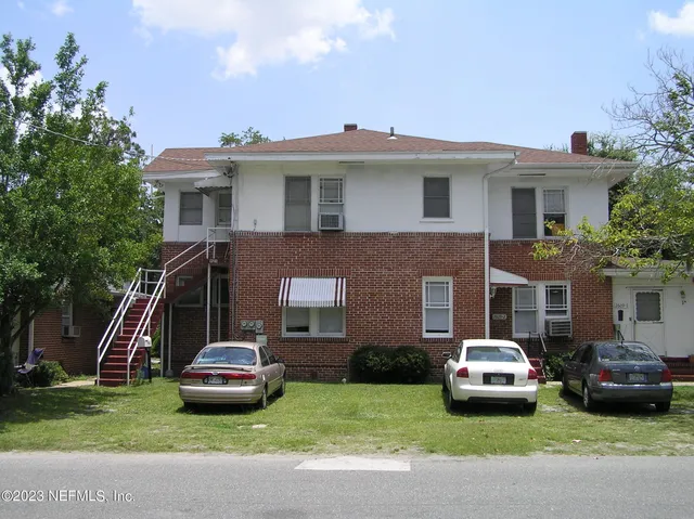a car parked in front of a house with a yard