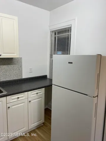 a kitchen with cabinets and a refrigerator