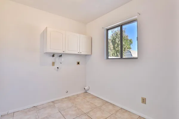 a view of kitchen with white cabinets and a window