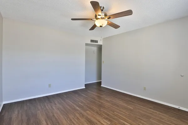 a view of an empty room with wooden floor