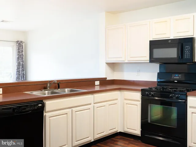 a kitchen with granite countertop a stove top oven microwave and cabinets