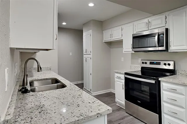 a kitchen with stainless steel appliances granite countertop a sink and a stove top oven with granite countertops