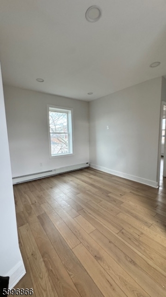 113 Broadway, Unit 1 Newark, NJ 07104 - Photo 3 of 8 an empty room with wooden floor and windows