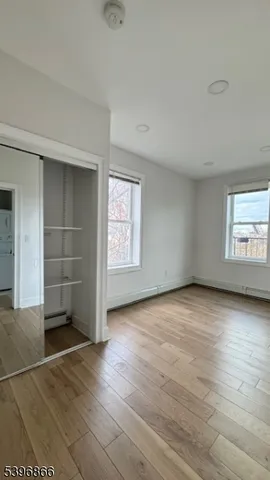 an empty room with wooden floor and window