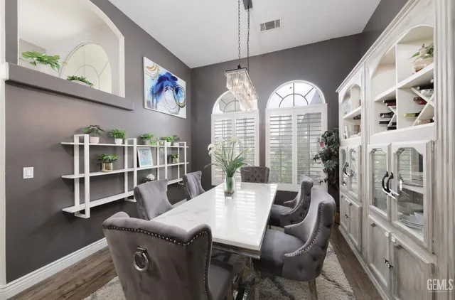 a view of a dining room with furniture a potted plant and a window