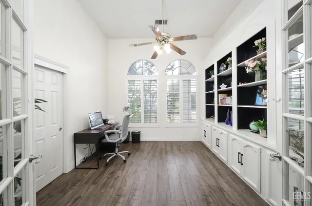 a workspace with wooden floor and windows