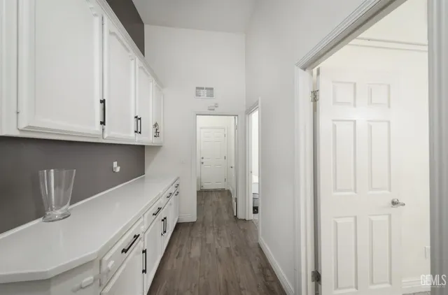 a kitchen with granite countertop white cabinets and sink