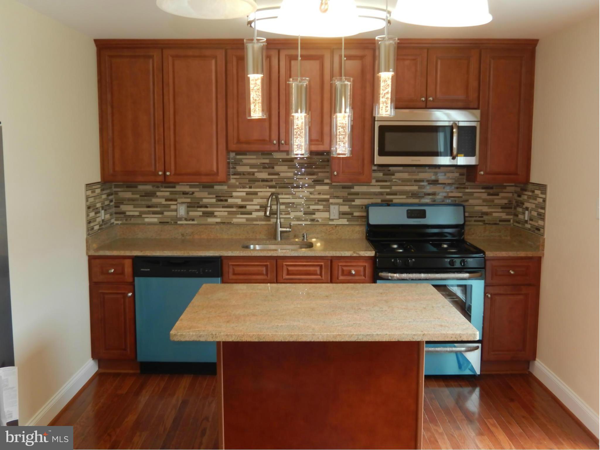 622 Charraway Road Baltimore, MD 21229 - Photo 11 of 28 a kitchen with a wooden floor and a microwave