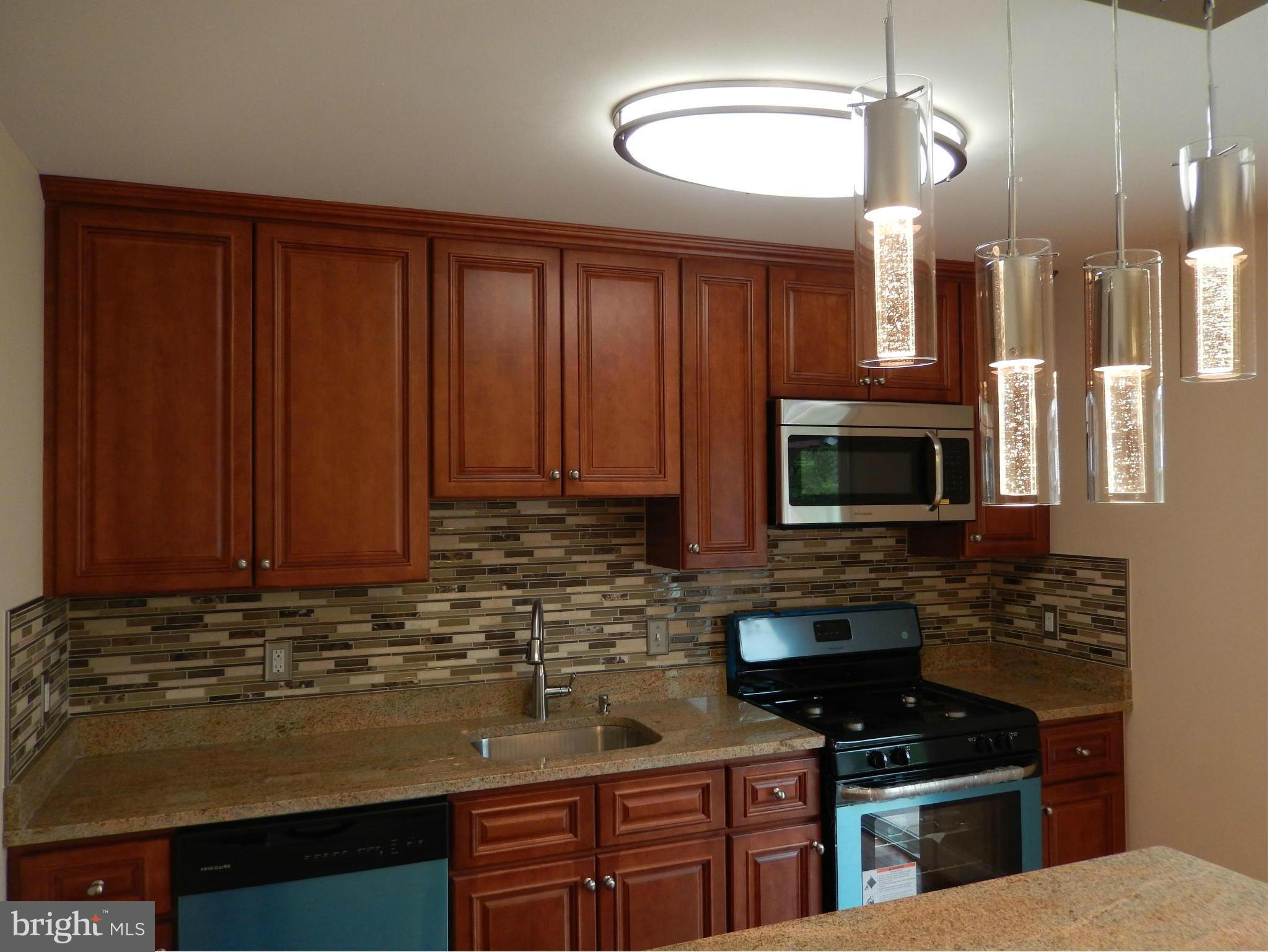 622 Charraway Road Baltimore, MD 21229 - Photo 12 of 28 a kitchen with stainless steel appliances granite countertop a stove a sink and a microwave