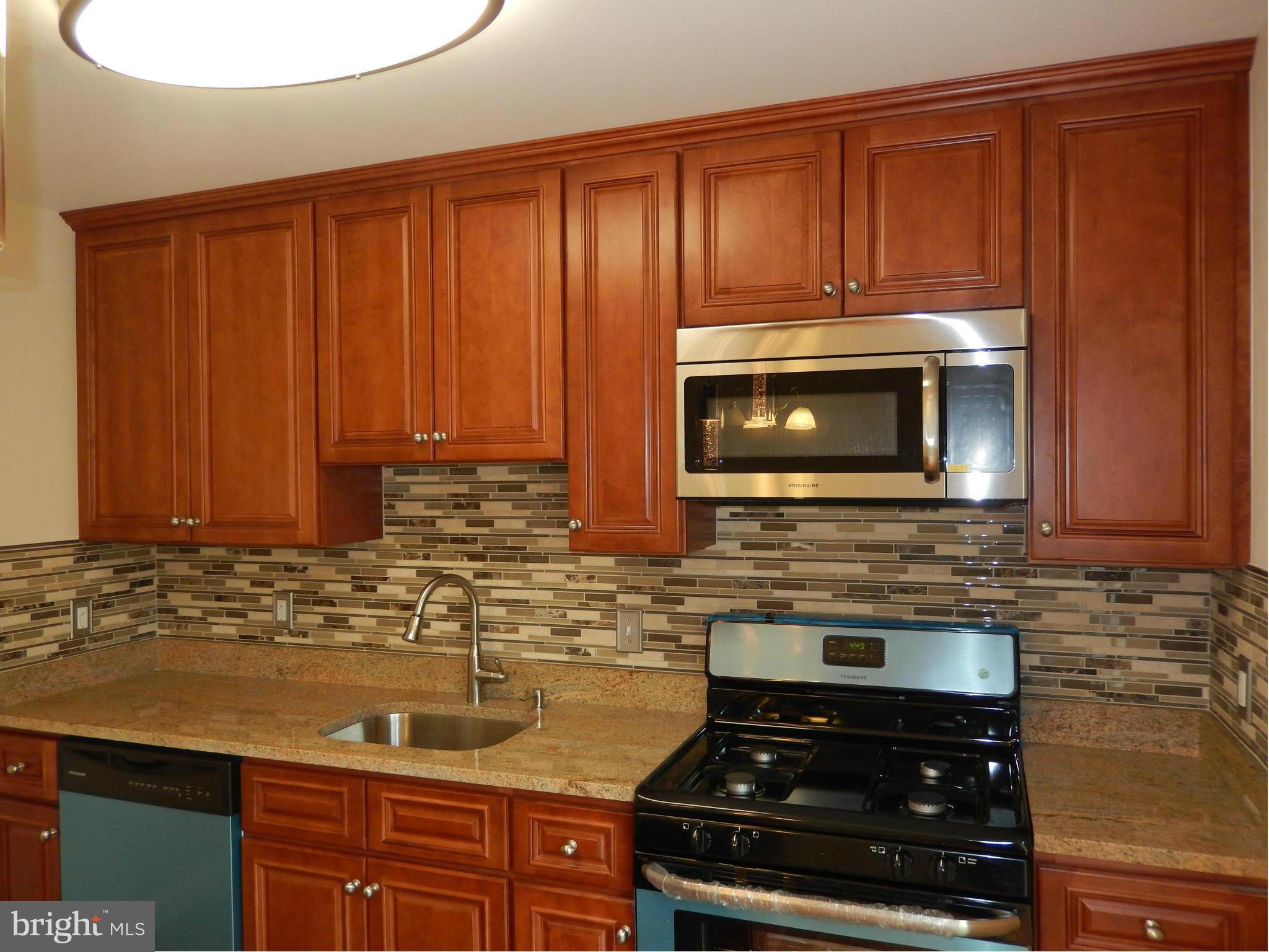 622 Charraway Road Baltimore, MD 21229 - Photo 14 of 28 a kitchen with granite countertop stainless steel appliances a stove a microwave and oven