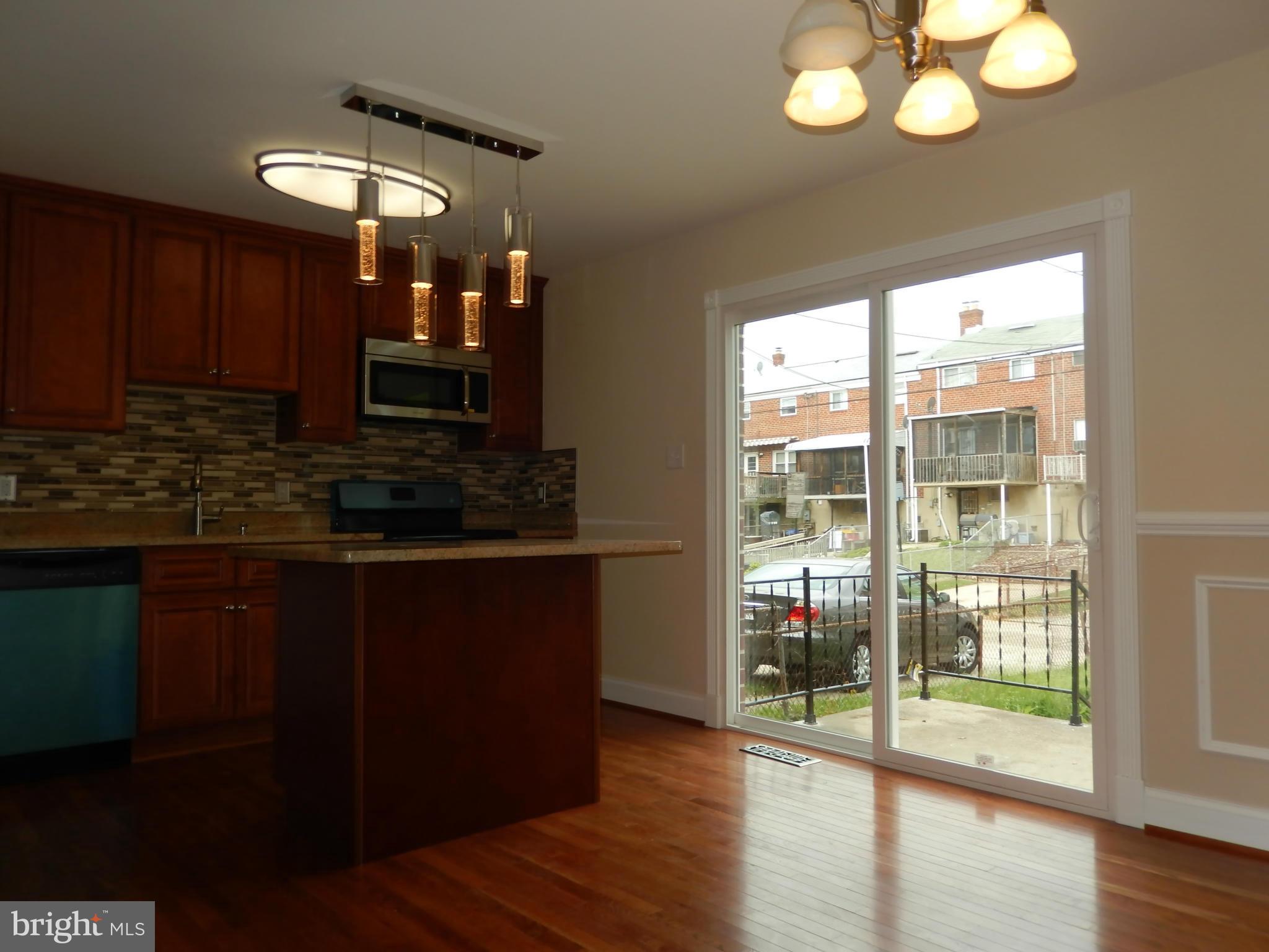 622 Charraway Road Baltimore, MD 21229 - Photo 25 of 28 a kitchen with wooden floor and large cabinets