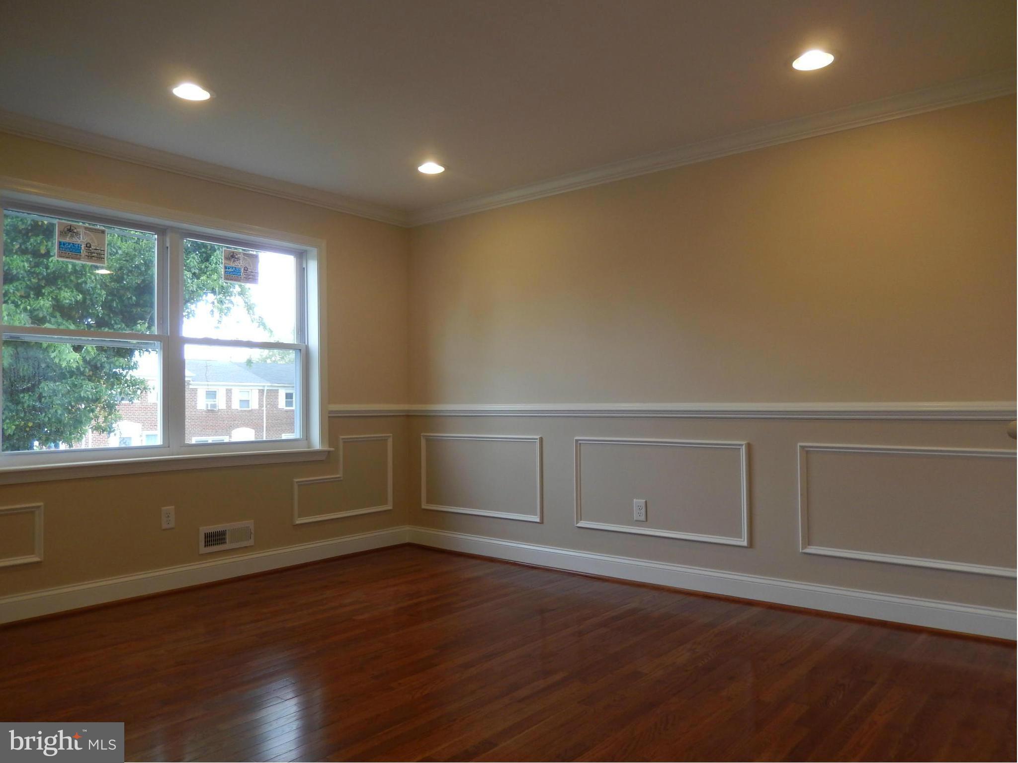 622 Charraway Road Baltimore, MD 21229 - Photo 5 of 28 an empty room with wooden floor and window