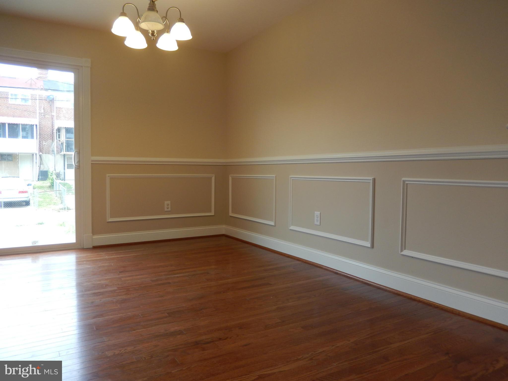 622 Charraway Road Baltimore, MD 21229 - Photo 8 of 28 a view of an empty room with wooden floor and a window
