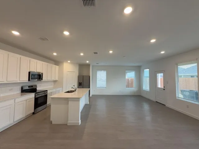 a large white kitchen with stainless steel appliances