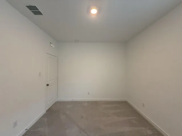 a kitchen with a refrigerator and a wooden floor