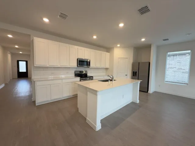 a kitchen with white cabinets and black appliances