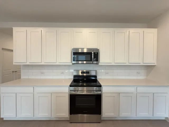 a kitchen with a sink a stove top oven and white kitchen