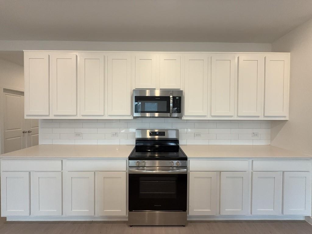 537 Ml Trce Way Princeton, TX 75407 - Photo 5 of 40 a kitchen with white cabinets and black appliances