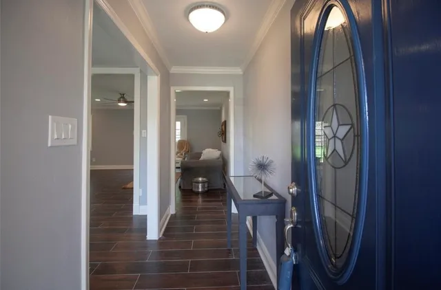 a view of a hallway with wooden floor and entryway