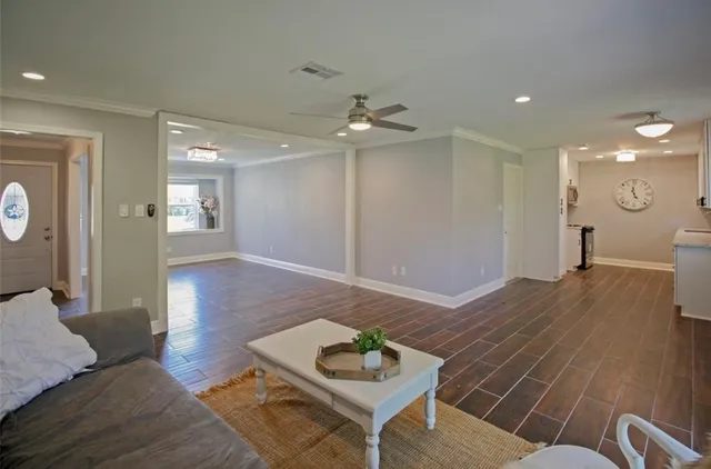 a living room with furniture and a wooden floor