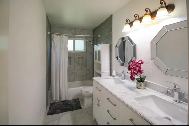 a bathroom with a double vanity sink mirror and shower