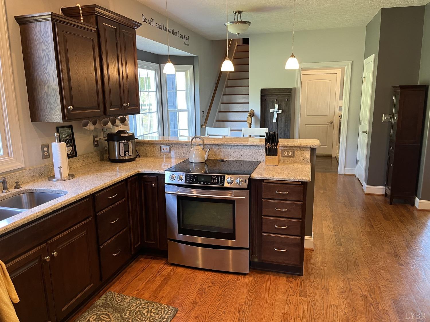 1959 Founding Way Road Goode, VA 24556 - Photo 11 of 65 a kitchen with stainless steel appliances granite countertop wooden cabinets a sink and a stove