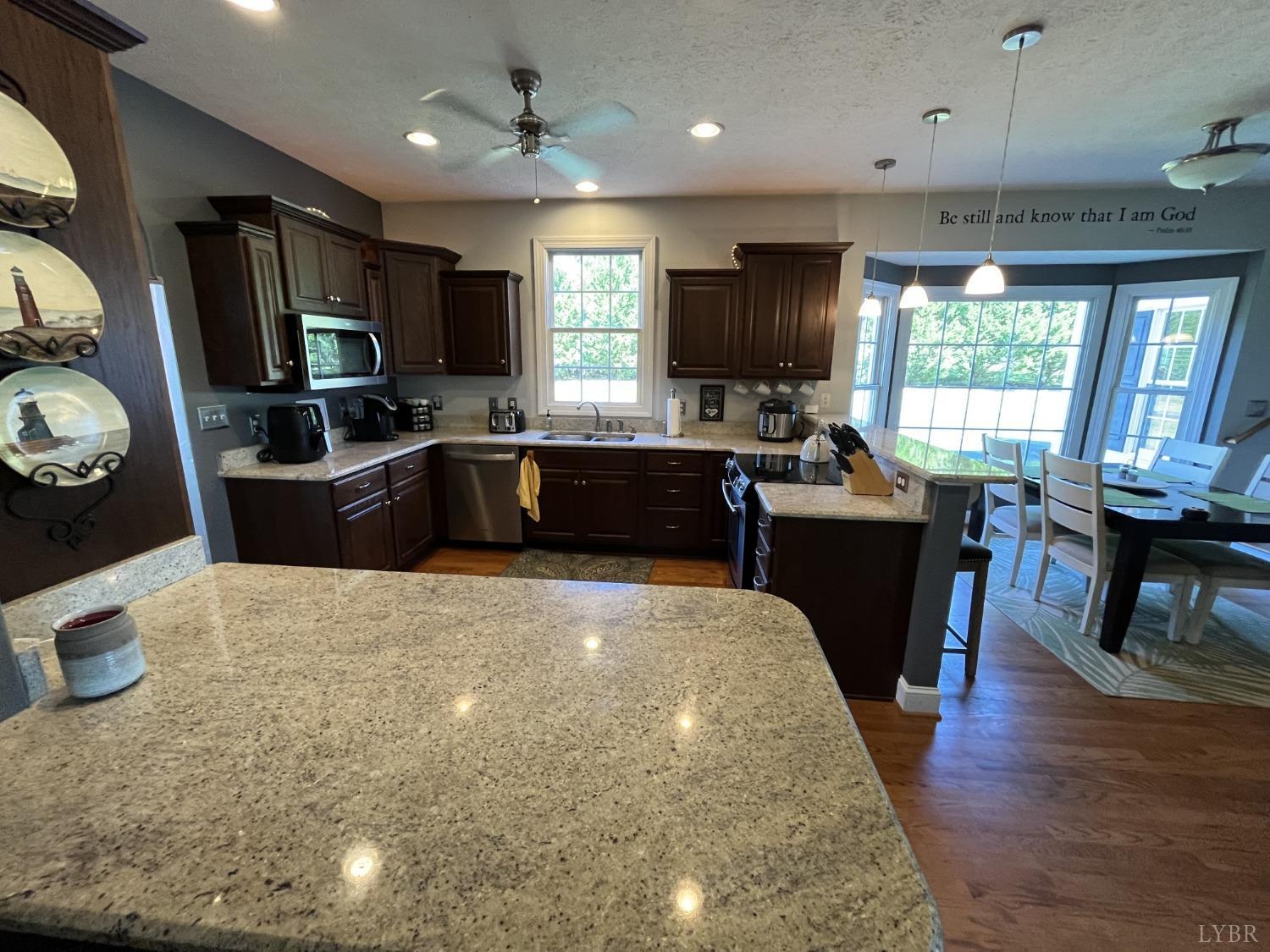 1959 Founding Way Road Goode, VA 24556 - Photo 12 of 65 a large kitchen with a stove a sink dishwasher a dining table and chairs with wooden floor