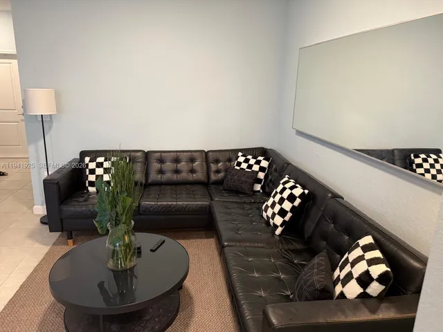 a living room with furniture and flowers