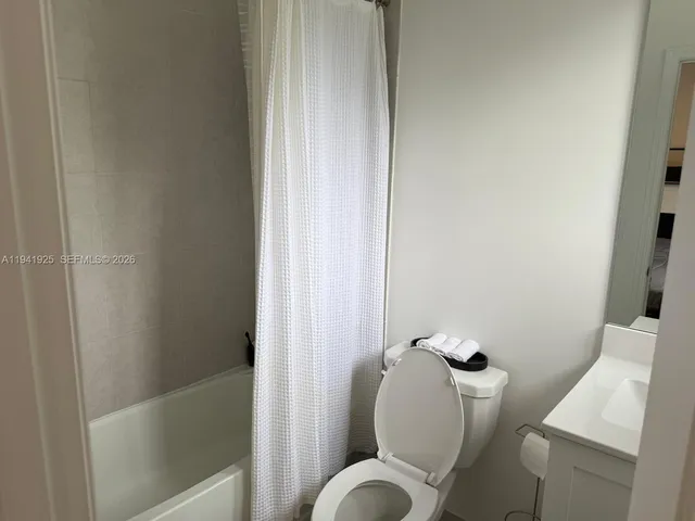 a white toilet sitting next to a bathroom sink and tub