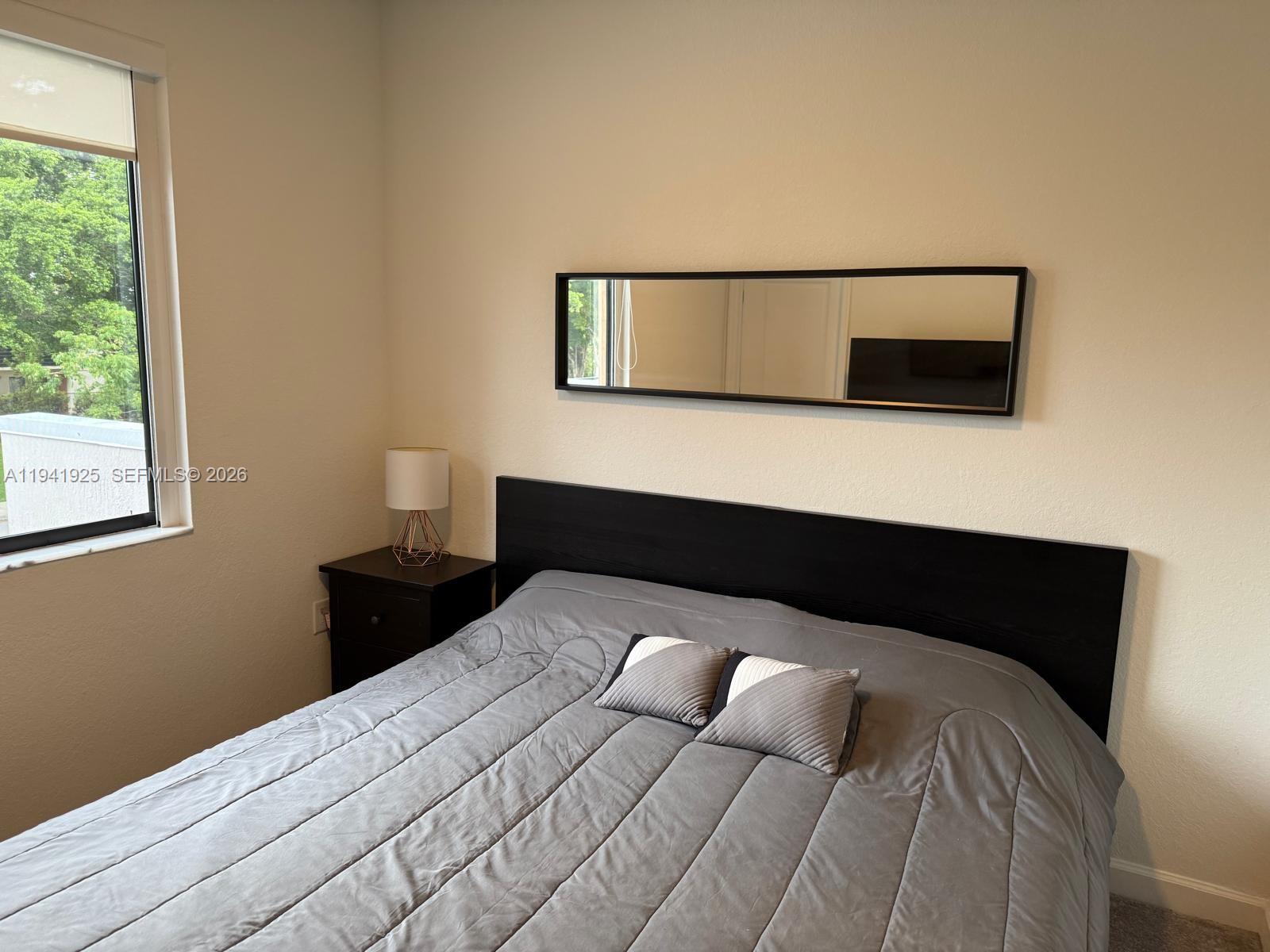 887 Northeast 211th Street Miami, FL 33179 - Photo 21 of 25 a bedroom with a bed and a window