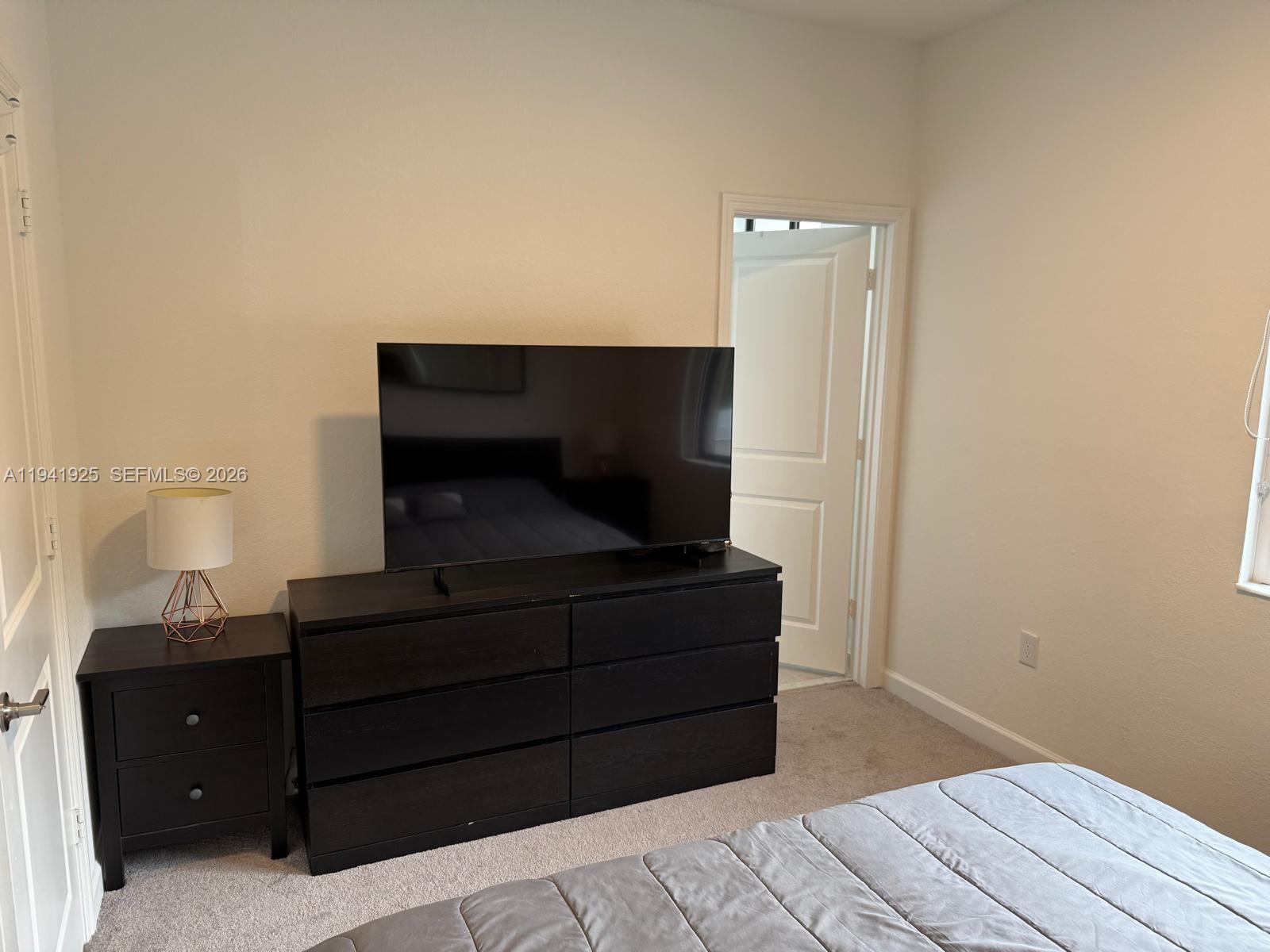 887 Northeast 211th Street Miami, FL 33179 - Photo 22 of 25 a living room with a couch and a potted plant on dresser