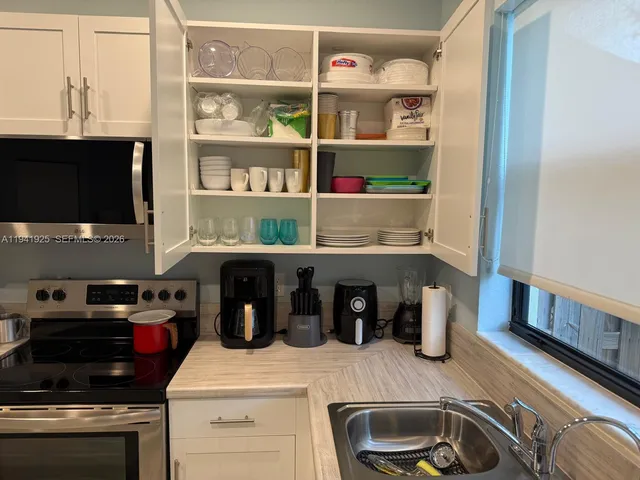 a kitchen with a sink and a stove top oven