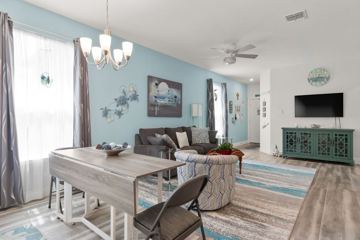 237 Benmyrtle Trail Georgetown, TX 78626 - Photo 7 of 22 Living area with wood finished floors, a chandelier, and a ceiling fan