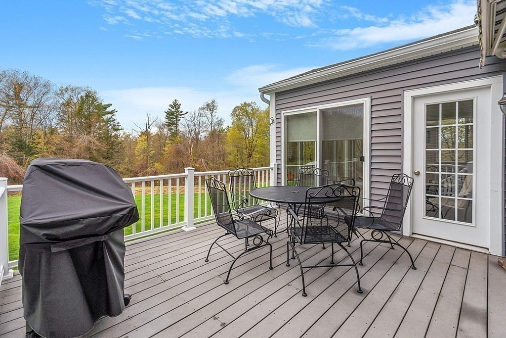 64 Walnut Street Rutland, MA 01543 - Photo 34 of 40 a view of a roof deck with table and chairs with wooden floor and fence