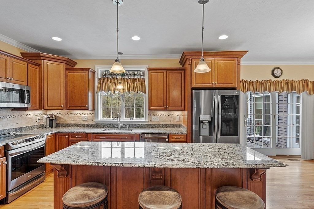 64 Walnut Street Rutland, MA 01543 - Photo 10 of 40 a kitchen with granite countertop a sink a stove and a wooden cabinets