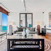 a living room with furniture a large window and wooden floor