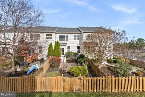 a view of a house with a small yard and wooden fence