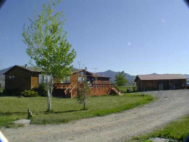 810 223rd Road Rifle, CO 81650 - Photo 6 of 9 a view of a house with a yard and table and chairs under an umbrella