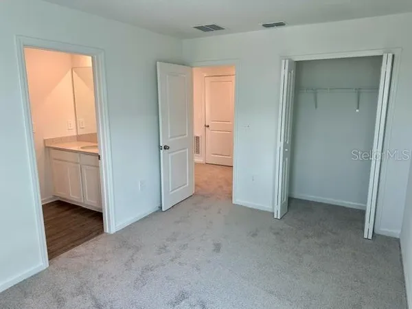 an empty room with windows and closet