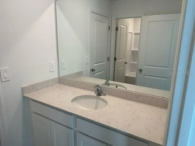 a bathroom with a sink vanity granite and a mirror
