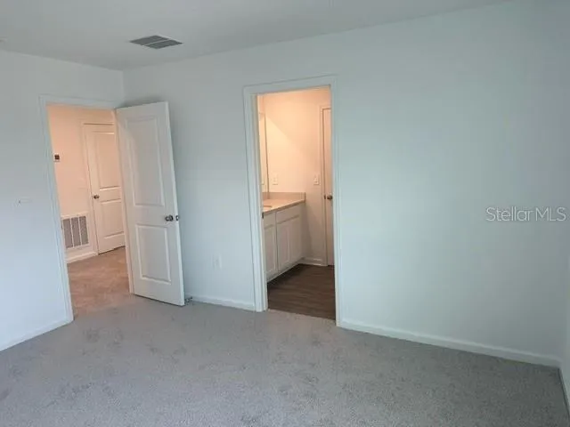 an empty room with a window and a kitchen