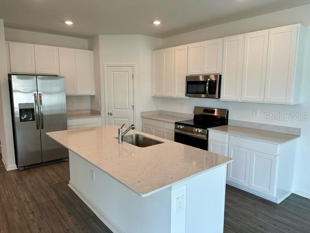 4734 Southwest 83rd Loop Ocala, FL 34476 - Photo 2 of 28 a kitchen with kitchen island a sink stainless steel appliances and white cabinets