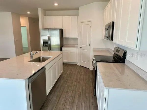 a kitchen with white cabinets and refrigerator