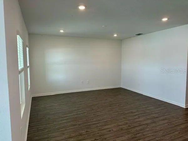 an empty room with wooden floor and a window